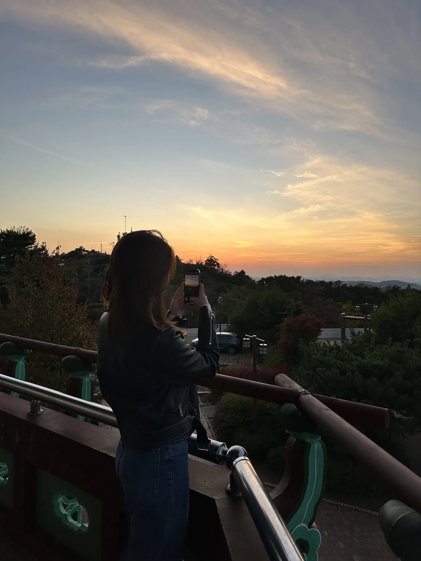 Selina photographing the sunset from a lookout.